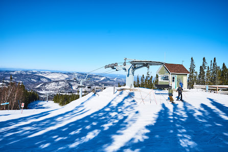 View of Mont Edouard ski resort in L'Anse-Saint-Jean, Quebec, Canada, featuring a ski lift amidst a stunning winter scene bustling with winter sports activities.