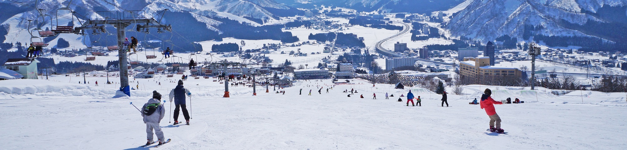 Iwappara in Japan - a group of people skiing down a snow covered mountain.