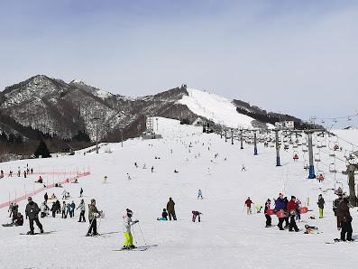 View of the bustling Iwappara ski resort in Chūbu, Honshu, Japan, featuring skiers descending snow-covered slopes, amidst a captivating winter scenery.