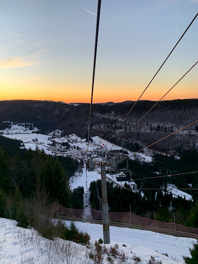 Winter sports scene at Mijoux - La Faucille ski resort in France, featuring a charming chalet, active ski lift, and breathtaking winter landscapes.