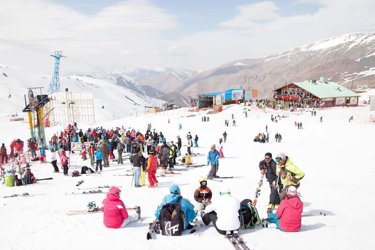 Dizin International in Iran - a group of people sitting in the snow.