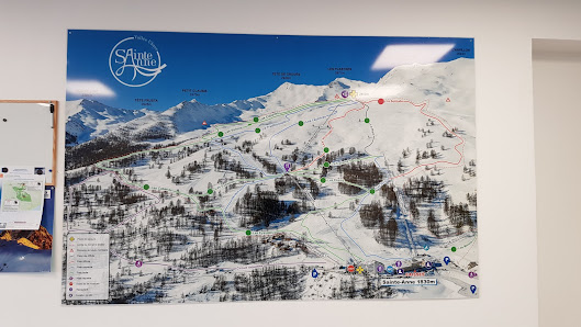A stunning ski resort in Sainte-Anne la Condamine, France showcasing winter sports activity amidst a magnificent mountain backdrop, and a quaint chalet nestled in the snow.