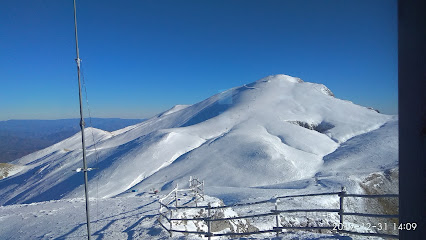 View of the snow-covered Falakro Mountain in Drama, Greece featuring a challet and ski resort. The mountain's slopes are blanketed in pristine white snow, making a captivating winter scene.