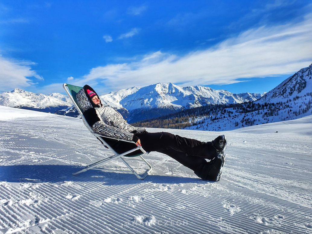 Cima Piazzi San Colombano in Italy - a person laying on a chair in the snow.