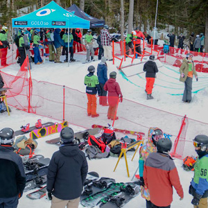 A bustling winter sports scene at Mont Orignal in Quebec Canada featuring skiers enjoying the snow-covered slopes and a ski lift in the distance.