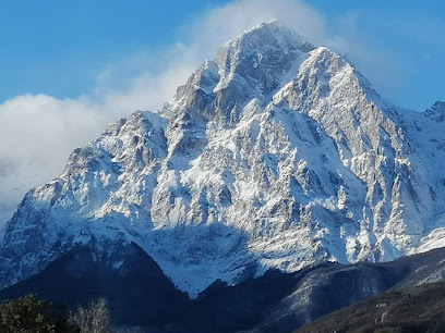View of the breathtaking Gran Sasso mountain in Abruzzo, Italy, partially covered in snow. A small chalet is present, tucked amidst the stunning winter scenery.