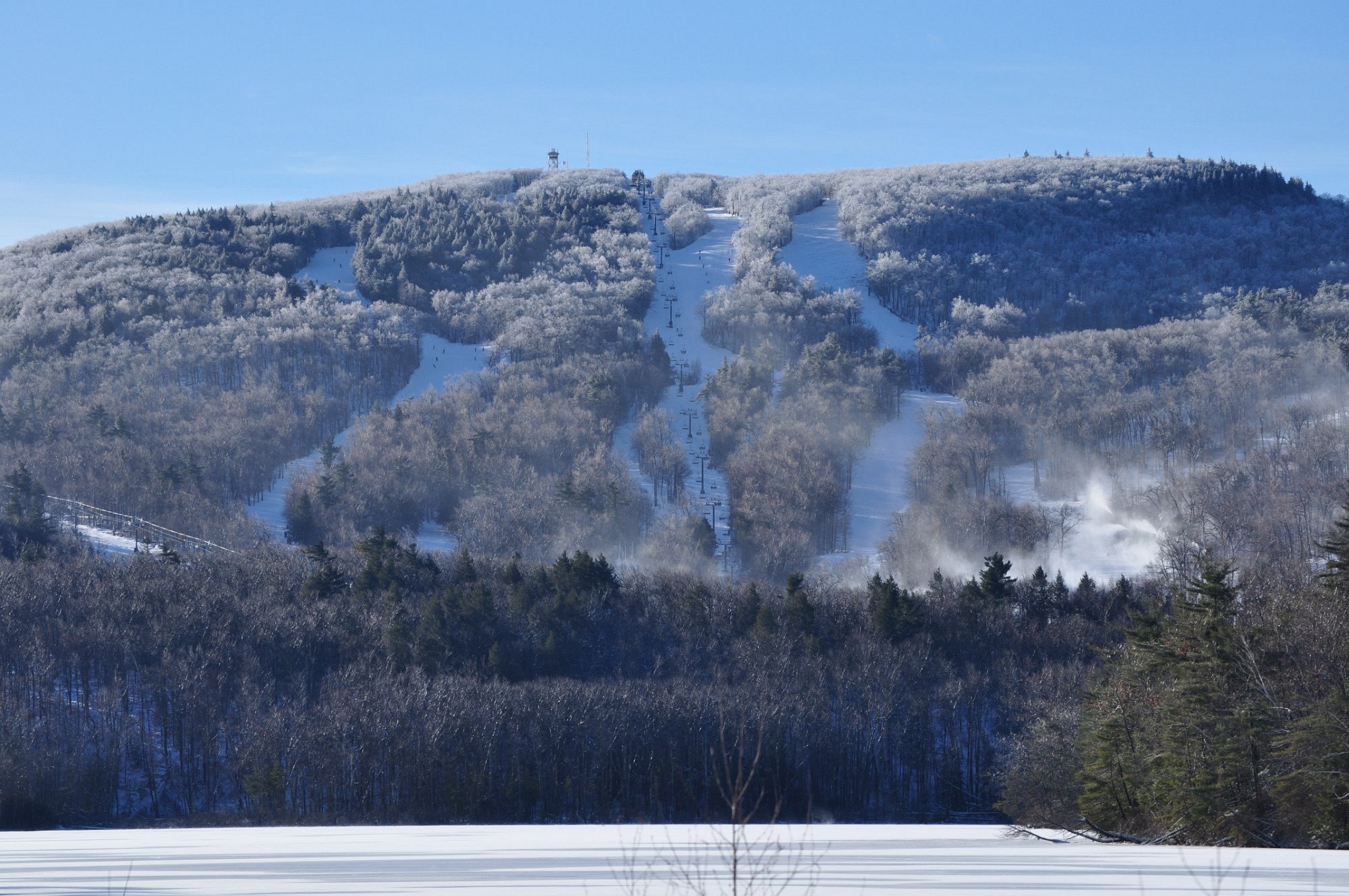 Wachusett Mountain Ski Area in USA - a mountain covered in snow with trees in the background.