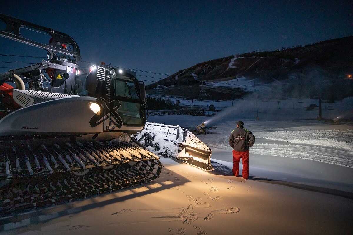 Granby Ranch in USA - a man standing in the snow next to a snow machine.