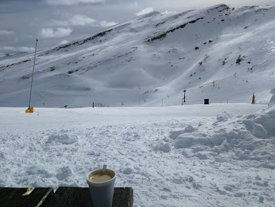 View of a charming chalet amidst a busy ski resort in Alto Campoo, Cantabria, Spain. The scene beautifully captures the essence of winter sports amidst stunning snow-dusted scenery.