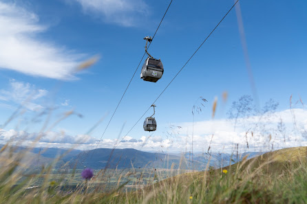 Ski lift traversing the picturesque landscape of Nevis Range in Fort William, Scotland, with a tiny glimpse of a chalet in the distance.