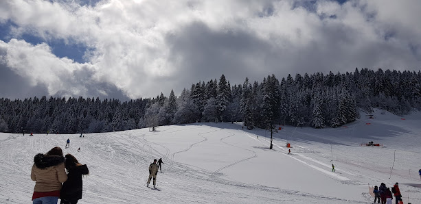 Winter sports scene at La Dôle | Les Tuffes in France featuring a ski resort a chalet and a skier enjoying the snowy mountainscape.