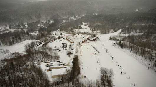 View of the bustling ski resort at Titus Mountain in The Adirondacks, New York. Winter sports enthusiasts are seen in action amidst stunning winter scenery.