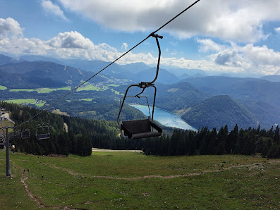 View of the Gemeindealpe Mitterbach ski resort in Lower Austria featuring a ski lift leading up to a picturesque mountain with a chalet nestled subtly in the scene.