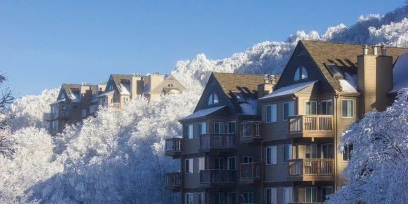 View of Sugar Mountain Ski Resort in North Carolina, featuring a charming chalet nestled amidst the stunning winter scenery of a snowy mountain range.