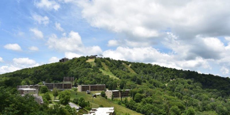 A scenic view of Sugar Mountain Ski Resort in North Carolina featuring a mountain backdrop a cozy chalet and a ski lift servicing the winter sports enthusiasts.