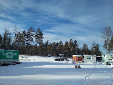 Winter sports enthusiasts enjoying their activities at a sports centre in Zavyalikha, Russia, amidst stunning winter scenery with a charming chalet in the backdrop.