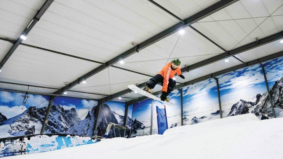 Snowplanet – Silverdale in New Zealand - a snowboarder performing a trick in the snow.