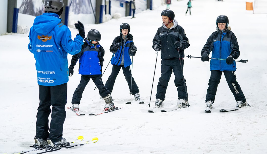Snowplanet – Silverdale in New Zealand - a group of people skiing down a snowy hill.