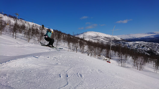 A skier navigates a snowy slope at the Bjorli ski resort in Gudbrand Valley Norway. A ski lift is visible in the background contributing to the vibrant winter sports scene.