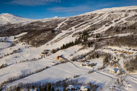 View of Bjorli ski resort in Norway highlighting a winter sports scene with a ski lift and chalet amidst an inviting snowy landscape.