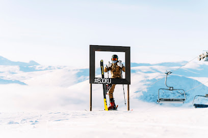 A skier navigating a slope using a ski lift at Bjorli Ski Resort in Norway. The snow-covered mountain and winter sports scene enhance the beauty of the ski resort.