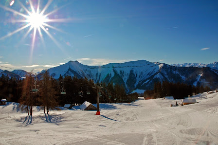 Winter sports enthusiasts enjoying a day at the Gaissau-Hintersee ski resort in Austria, with a charming challet nestled amidst the expansive snow-covered landscape.