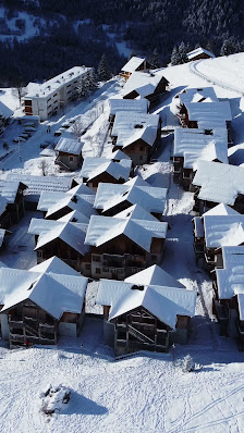Winter scenery at Albiez-Montrond in Savoie Mont Blanc, France showcasing a charming chalet, active ski resort with sports enthusiasts, wrapped in a serene snowy landscape.