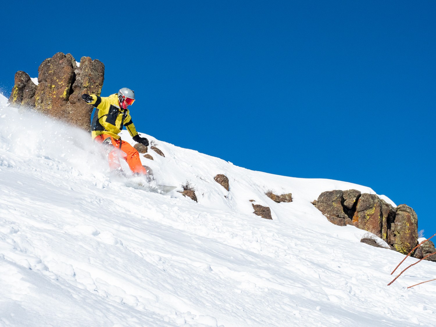 Magic Mountain in USA - a man riding a snowboard down a snow covered slope.