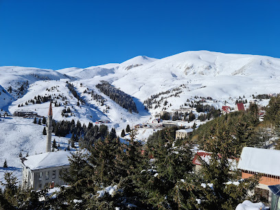 Winter view of Popova Sapka ski resort in North Macedonia, featuring a chalet amidst snowy slopes, serving as a hub for winter sports activities.