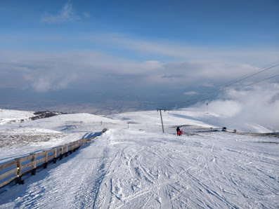 Winter sports enthusiasts enjoying the snowy landscape at the charming Popova Sapka ski resort in North Macedonia, beautifully surrounded by a pristine winter scenery.