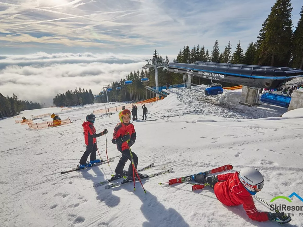 Černá hora – Janské Lázně in Czech Republic - a group of people skiing down a snow covered slope.