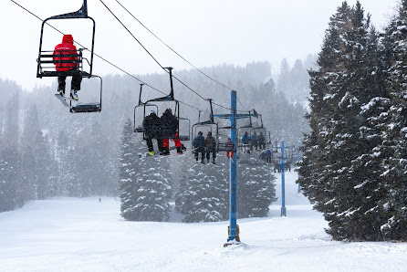 A ski lift in operation at Pajarito Mountain in Los Alamos New Mexico amidst a stunning winter scene. People are enjoying winter sports at the ski resort.