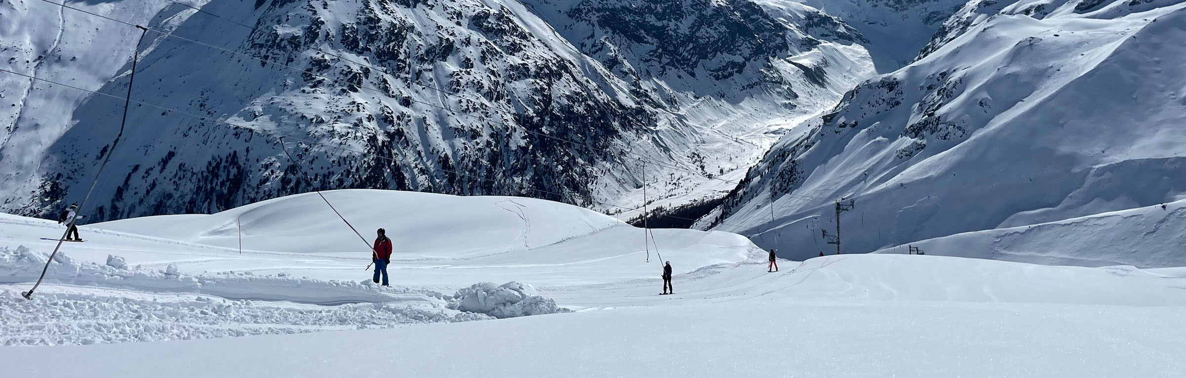 Arolla in Switzerland - a group of people skiing down a snowy mountain.