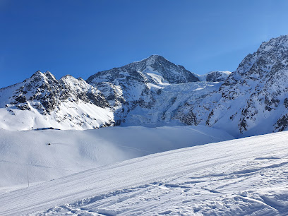 A skier enjoys a day on the slopes at a quaint ski resort in Arolla Switzerland. A charming challet and the stunning mountain landscape frame the winter sports scene beautifully.