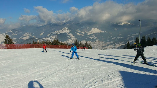 A skier glides down a slope at Olimpica-Borșa a bustling winter sports centre in Borsa Maramureș Romania. A charming chalet nestles in the snow-covered landscape of this popular ski resort.