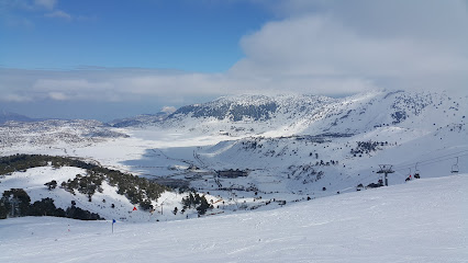 A picturesque view of Isparta Davraz Ski Resort in Turkey showcasing a charming chalet nestled amidst snow-covered slopes with the majestic mountains sitting in backdrop. A hub of winter sports activity.