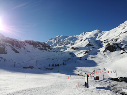 A skier on a winter sports scene at Gavarnie-Gèdre ski resort in France, with a picturesque challet in the background.