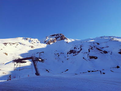 A picturesque ski resort in Gavarnie-Gèdre France capturing a welcoming challet and a functional ski lift. The serene winter sports centre offers an idyllic winter sports scene.