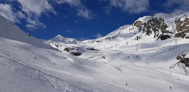 A chalet and a ski resort at the Gavarnie-Gèdre ski station in France complete with a winter sports scene snow-covered slopes and a skier in action.