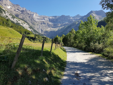 A charming chalet nestled at the base of a mountain at the Gavarnie-Gèdre ski station in France, basking in the glow of a sunny day, with a mountain bike parked near.