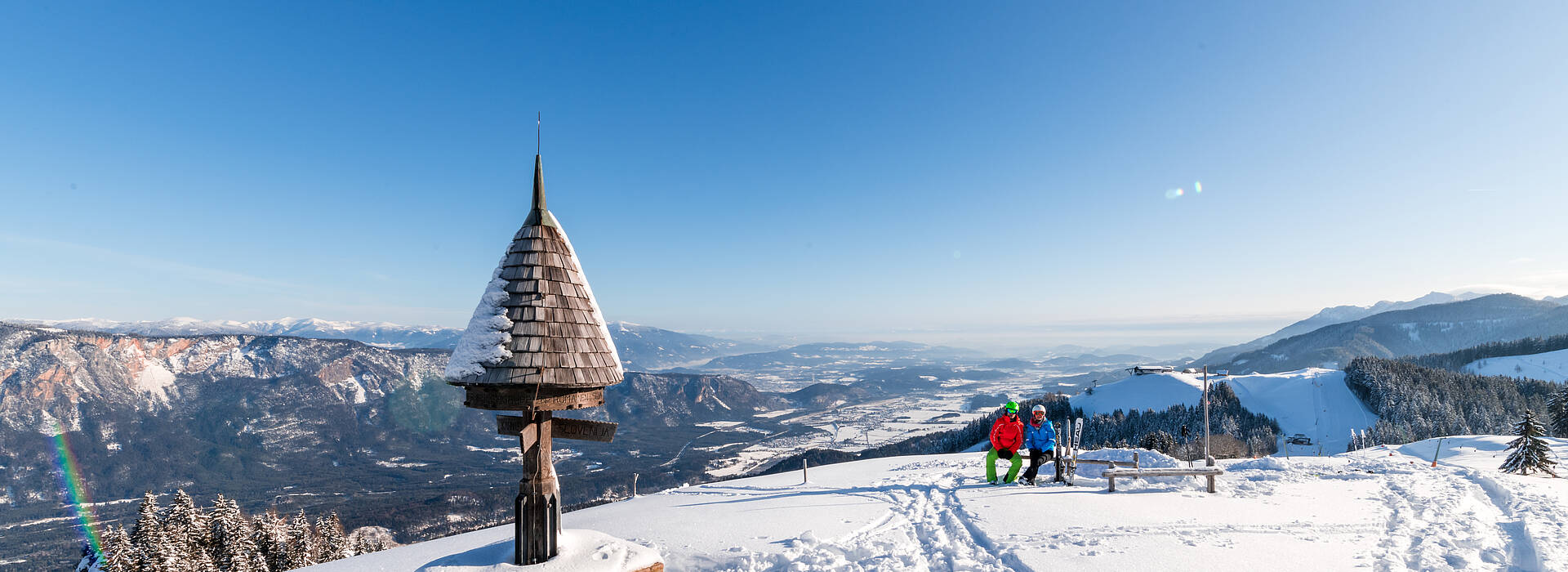 Arnoldstein Dreiländereck in Austria - a person standing on top of a snow covered mountain.