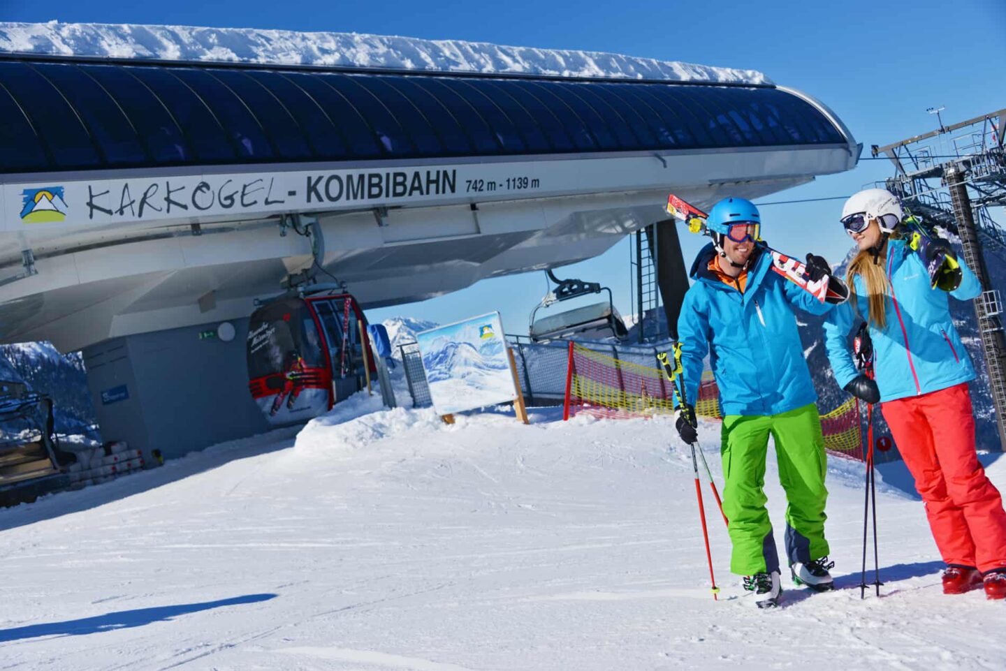 Karkogel – Abtenau in Austria - two skiers standing in front of a ski lift.