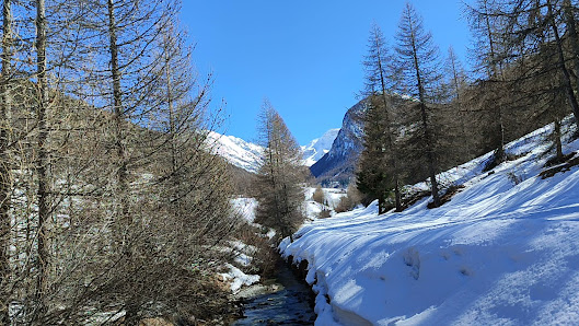 Winter scene in Ceillac en Queyras, France, featuring a quaint chalet amidst the stunning snowy landscape, with a majestic mountain view in the backdrop.