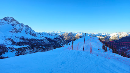 Skier enjoying a winter day at the Ceillac en Queyras ski resort in Hautes-Alpes, France, with a charming challet in the backdrop.
