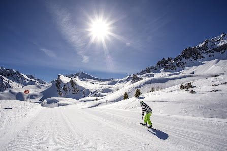 A skier navigates a frosty trail in the charming setting of Ceillac en Queyras France. Nestled against snowy peaks a quaint chalet overlooks the popular ski resort bustling with families.