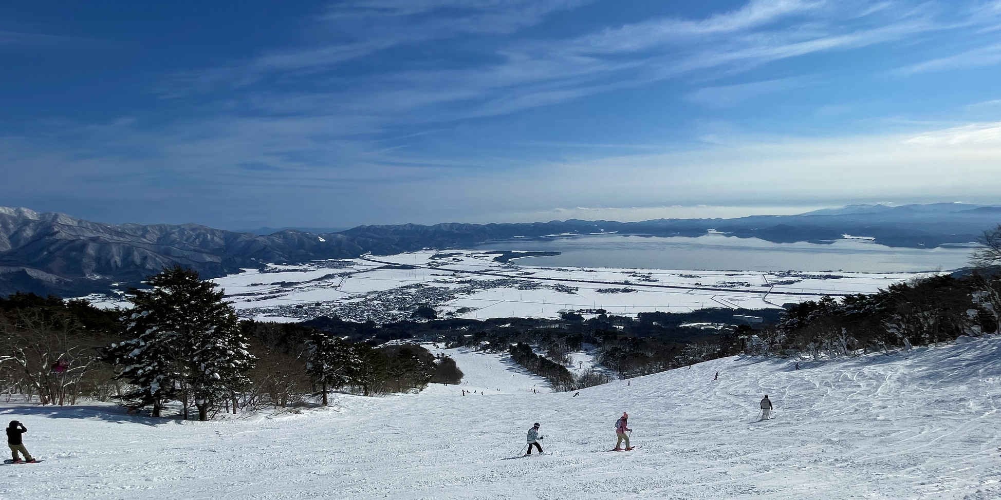 Inawashiro in Japan - a group of people skiing down a snowy slope.