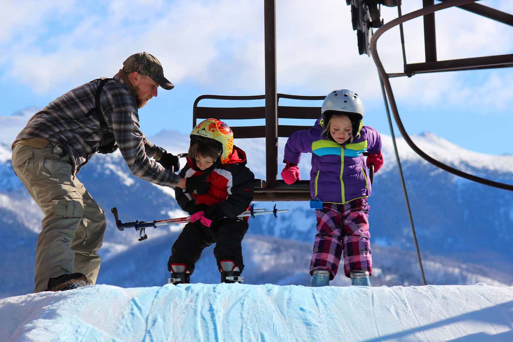 Maverick Mountain in USA - a man and two children on a ski slope.