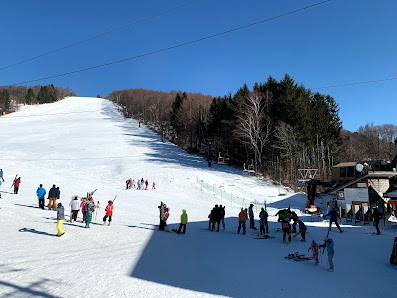 Winter scene at Sugadaira Kogen Taro ski resort in Japan, featuring a chalet, a ski lift, and snow-covered slopes frequented by skiers and snowboarders.
