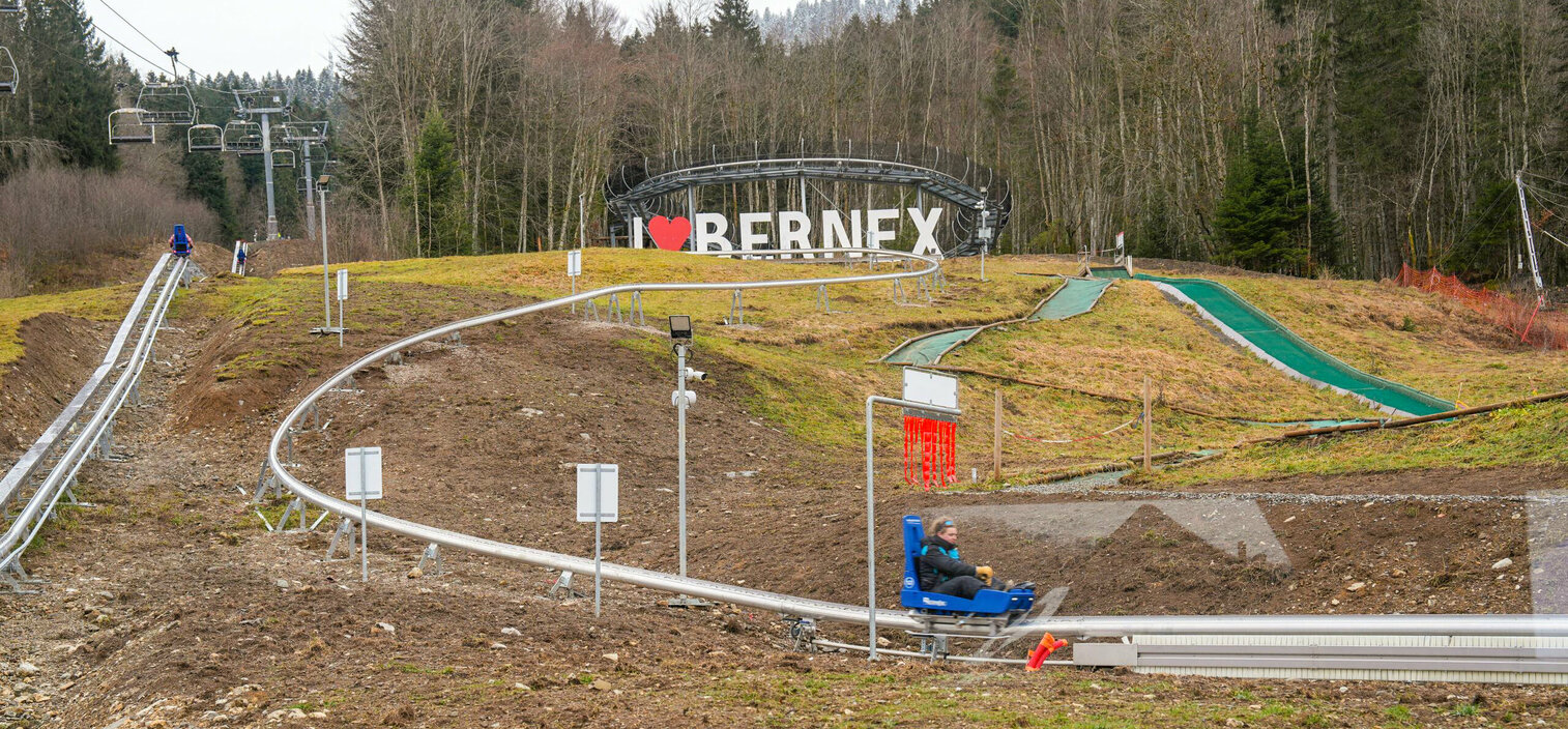 Bernex in France - a man sitting on top of a hill next to a sign.