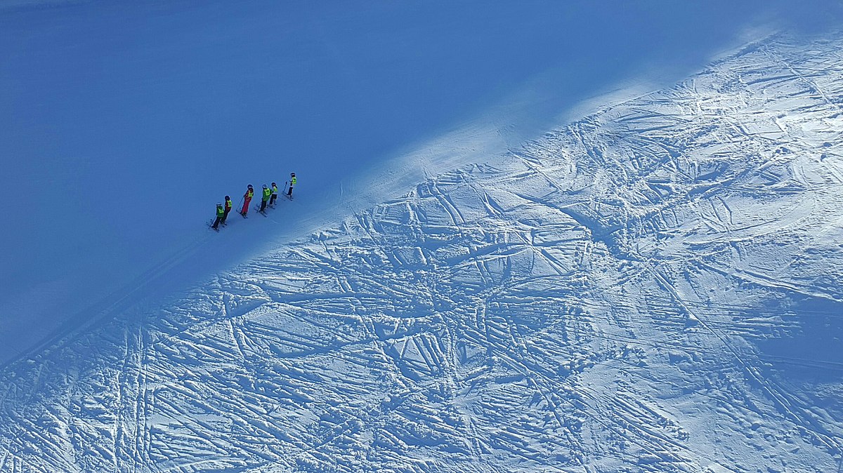 Tornik – Zlatibor in Serbia - a group of people skiing down a snow covered mountain.